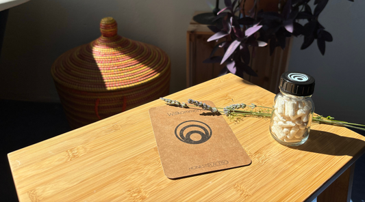 Honest Placebo wirkstofffreie Kapseln, Wasserglas und Ritualkarte auf einem Holztisch.